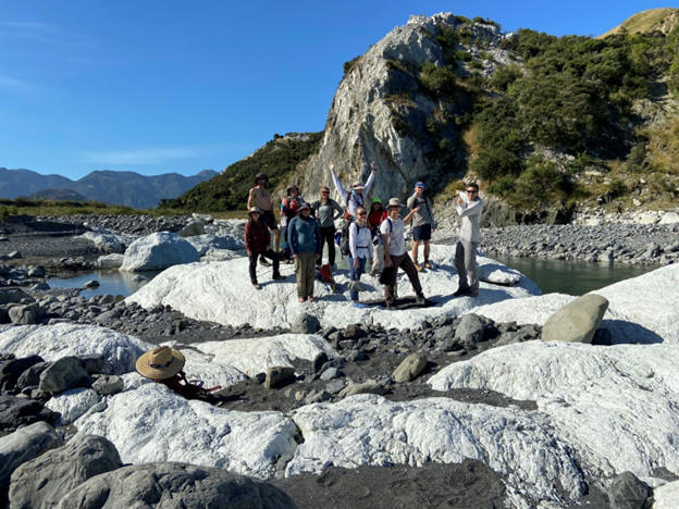 Field camp group at a scenic geological site on South Island